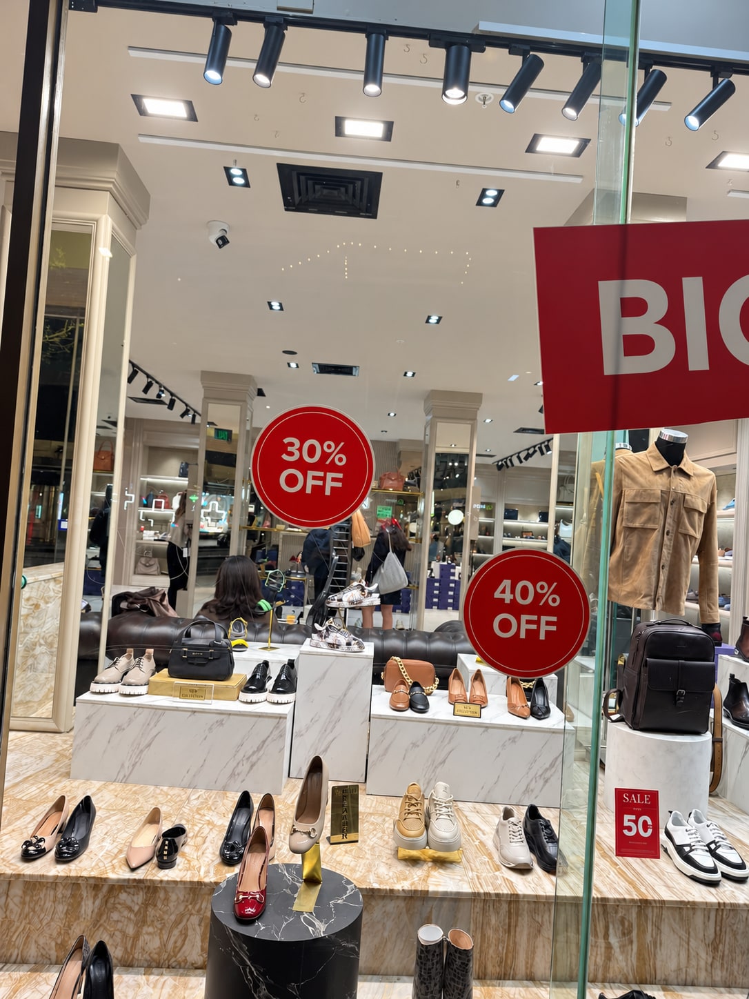 Barhion storefront before staging, with large red 30% and 40% OFF sale signs and products on marble-effect display blocks